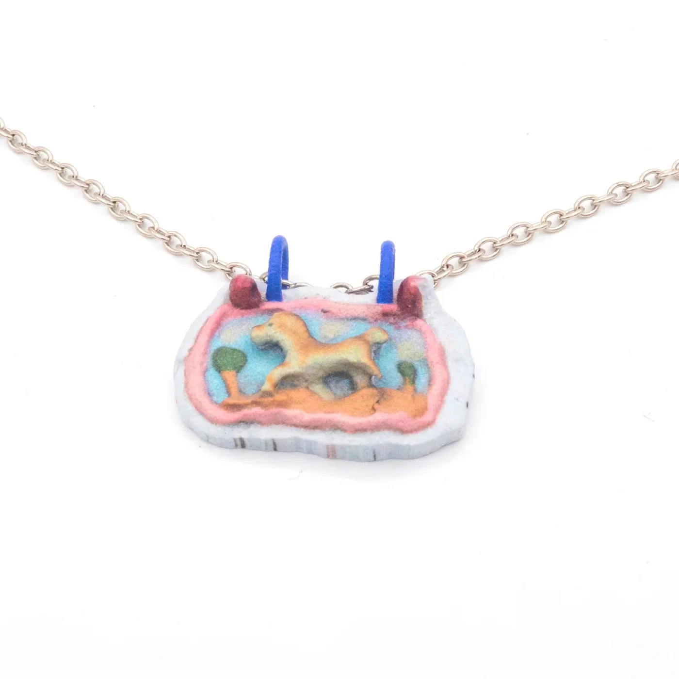 Necklace with a printed plaque: a pale horse trotting through a landscape with trees