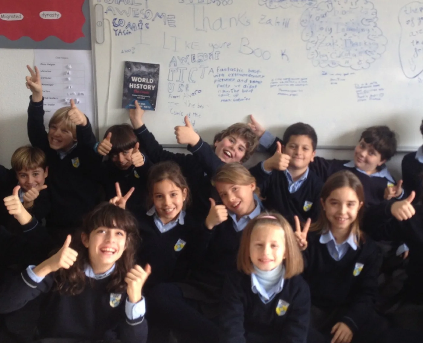 Schoolchildren in a classroom giving thumbs up, one holding a copy of World History: The Comic